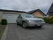 1999 Ford Fairlane - This silver sedan, identified by its grille badge, is parked in a paved driveway in front of a garage.