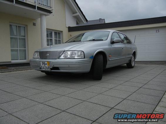 1999 Ford Fairlane sedan, silver, parked in front of a house and garage
