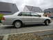 1999 Ford Fairlane - Silver 1999 Ford Fairlane sedan parked on a paved driveway in front of houses.