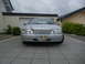 1999 Ford Fairlane - A silver sedan is parked in a driveway in front of a garage and house.