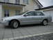 1999 Ford Fairlane - A silver sedan is parked on a tiled driveway in front of a modern house.