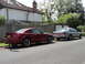 1999 Ford Fairlane - A silver sedan is parked on the street next to a red coupe.