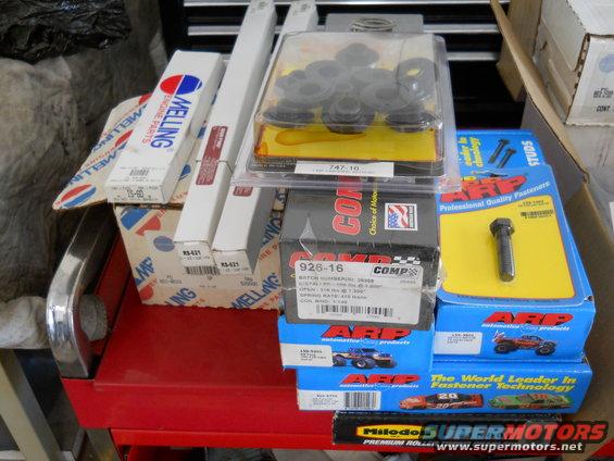 Engine parts including Melling and Comp Cams boxes, and ARP fasteners on a red cart