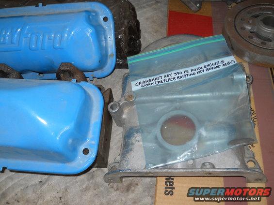 Blue Ford valve covers and an engine block with a baggie of parts on it