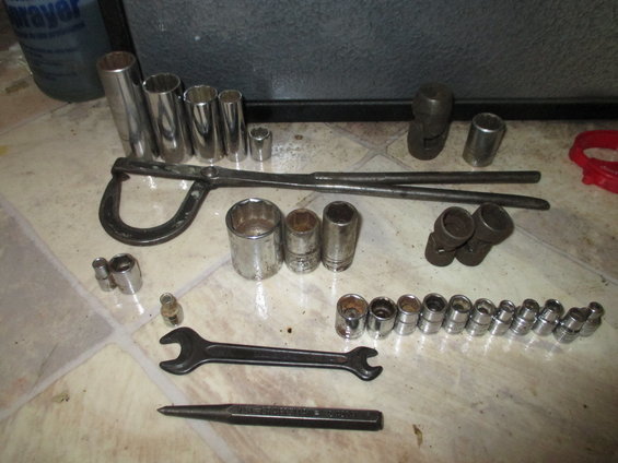 Assortment of mechanic's tools: sockets, a wrench, pliers, and a punch