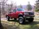 1996 Ford F-250 - This red 1996 Ford F-250 pickup truck is shown from a 3/4 front angle in an outdoor setting.