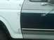 1986 Ford Bronco - Ford truck fender and door with chrome trim, undergoing bodywork.