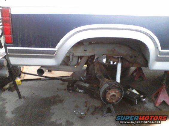 1986 Ford Bronco rear axle removed and supported by jack stands, undergoing repairs