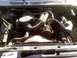 1986 Ford Bronco - Engine bay view showing hoses, fan, and other components. Text on fan shroud indicates caution.