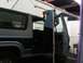 1986 Ford Bronco - A person is working on the interior of a two-tone gray and blue Ford Bronco, with the driver's door removed.