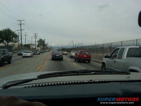 View from inside a vehicle looking out at highway traffic under an overcast sky