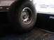 1986 Ford Bronco - A spare tire is secured inside the cargo area of a vehicle, with other vehicles visible through the windows.