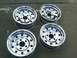 1986 Ford Bronco - Four shiny chrome wheels are displayed on a concrete surface.