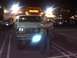 1986 Ford Bronco - A silver 1986 Ford Bronco is parked in front of a Hooters restaurant at night, with a man standing in front of the vehicle.