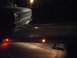 1986 Ford Bronco - A truck's front end is visible, a Chevrolet emblem and a license plate, illuminated by amber lights on a flatbed trailer.