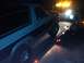 1986 Ford Bronco - A tow truck is loading a Ford Bronco onto its flatbed in the dark.