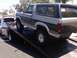 1986 Ford Bronco - A Ford Bronco is loaded onto a tow truck, with a tow truck visible behind it.