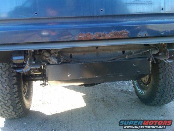 Rear undercarriage of dark blue SUV with rust on the body panel and BFGoodrich tires