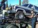 1986 Ford Bronco - A tow truck operator secures a two-tone Ford Bronco for transport.