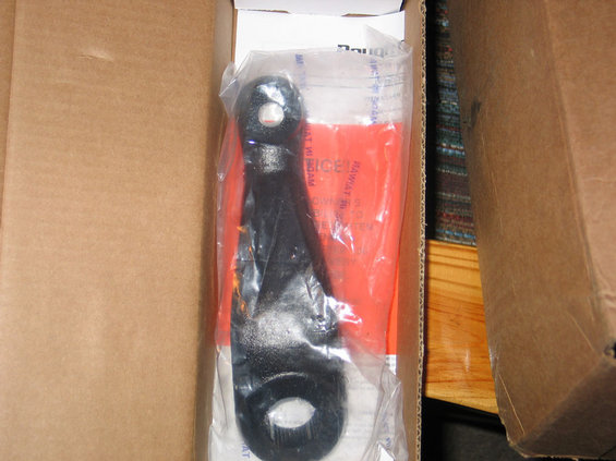 Black metal part in plastic packaging inside a cardboard box