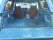 1986 Ford Bronco - Interior view of a blue SUV, showing the rear cargo area and front seats.