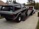 1986 Ford Bronco - Ford Bronco on a flatbed tow truck, viewed from the rear. A tow truck is behind it.