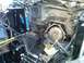 1986 Ford Bronco - The engine bay of a vehicle is shown with the transmission removed, revealing internal components and suspension parts.