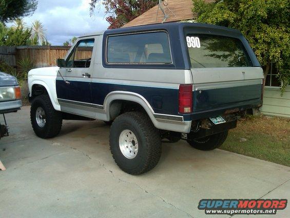1986 Ford Bronco, two-tone paint, lifted suspension, off-road tires, number 990 on rear window