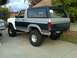 1986 Ford Bronco - Rear view of a lifted 1986 Ford Bronco with off-road tires and two-tone paint scheme.