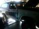 1986 Ford Bronco - This two-tone Ford Bronco is on a lift with its hood open, showing the engine bay.