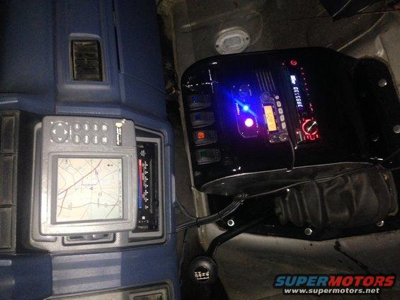 Vehicle interior showing aftermarket GPS unit and stereo with blue illuminated display