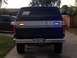 1986 Ford Bronco - Rear view of a Ford Bronco, showing its taillights and license plate. A second vehicle is visible to the left.