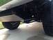 1986 Ford Bronco - The undercarriage of a vehicle shows a skid plate and off-road tires.