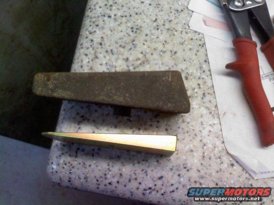 two wedges, one rusty and one gold, next to red-handled tin snips on a speckled counter