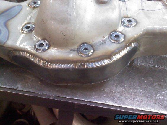 Close-up of a welded differential housing with visible bolt holes and weld beads