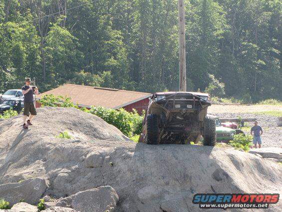 Rear view of off-road buggy climbing large rocks