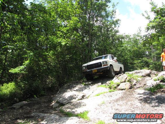 White pickup truck on rocky terrain, front grille visible