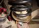 1992 Ford Bronco - Close-up view of a suspension coil spring and its mounting hardware, likely during installation or repair.