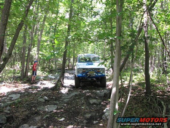 White 1978 Ford Bronco with blue roll cage and winch on rocky trail