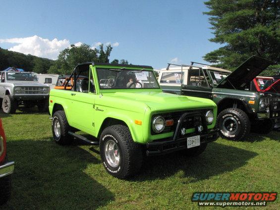 Lime green 1978 Ford Bronco parked on grass with other vehicles behind it