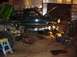 1992 Ford Bronco - A dark green SUV is in a garage with its hood open, undergoing mechanical work. Another vehicle is partially visible to the left.