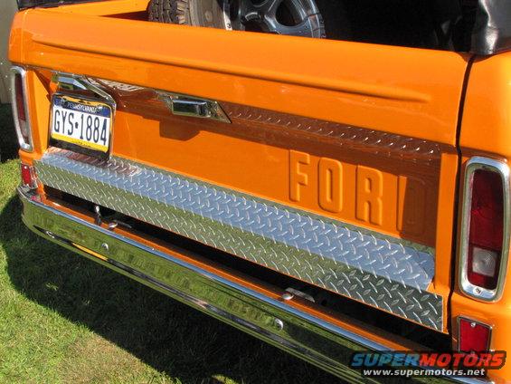 Orange Ford pickup truck tailgate with diamond plate accent and Pennsylvania license plate GYS-1884