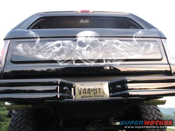 Black SUV's rear window has airbrushed skulls; New Jersey license plate V44 BY