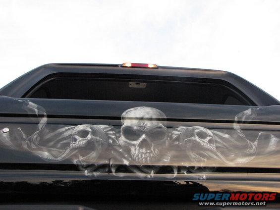 airbrushed skulls on the tailgate of a black truck