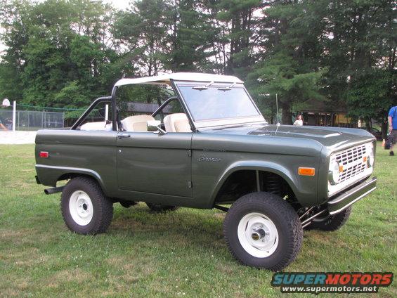 1979 Ford Bronco parked on grass with trees in background