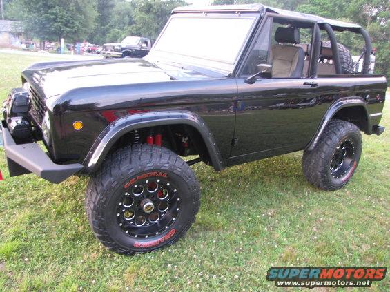Black Ford Bronco with aftermarket wheels and tires, lifted suspension, and roll cage