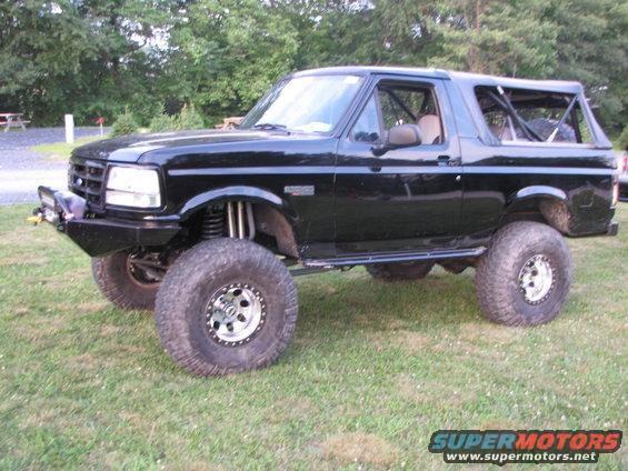 Black lifted SUV with off-road tires and roll cage