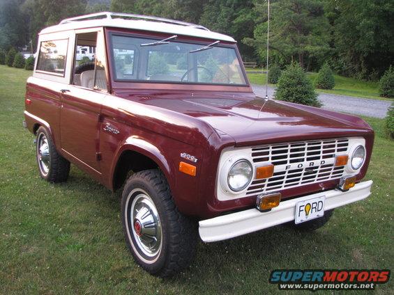Maroon 1978 Ford Bronco with white roof and grille, parked on grass
