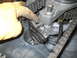 1992 Ford Bronco - Close-up view of an engine's internal components, including a timing chain and gears, being worked on by a gloved hand.