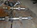 1992 Ford Bronco - Two metal shafts with splines and flanges are laid out on a workbench, possibly for repair or replacement.